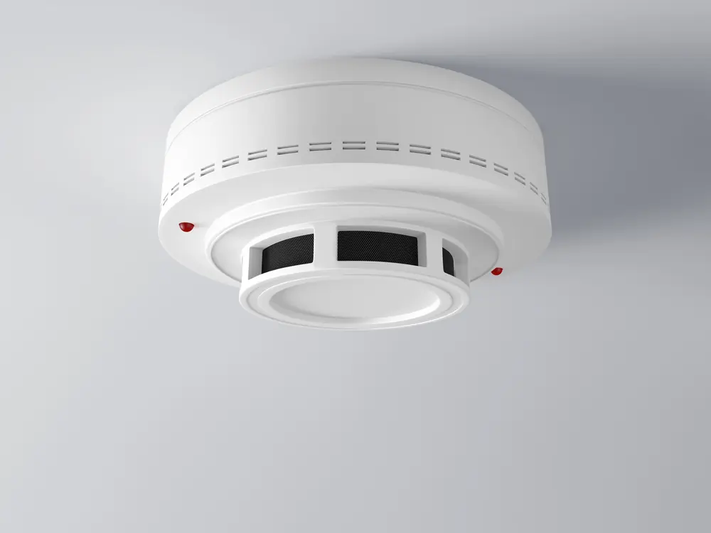 White smoke detector mounted on a ceiling